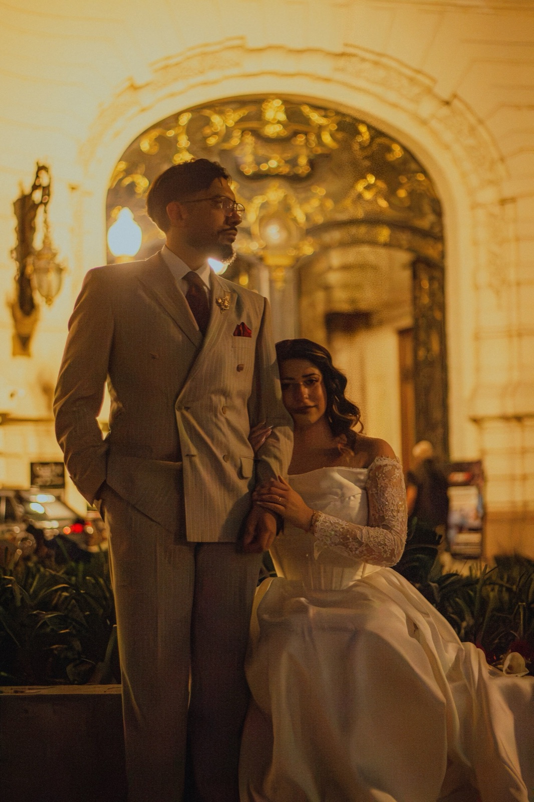 Luanne and Ramiro at the lit entrance of a palace