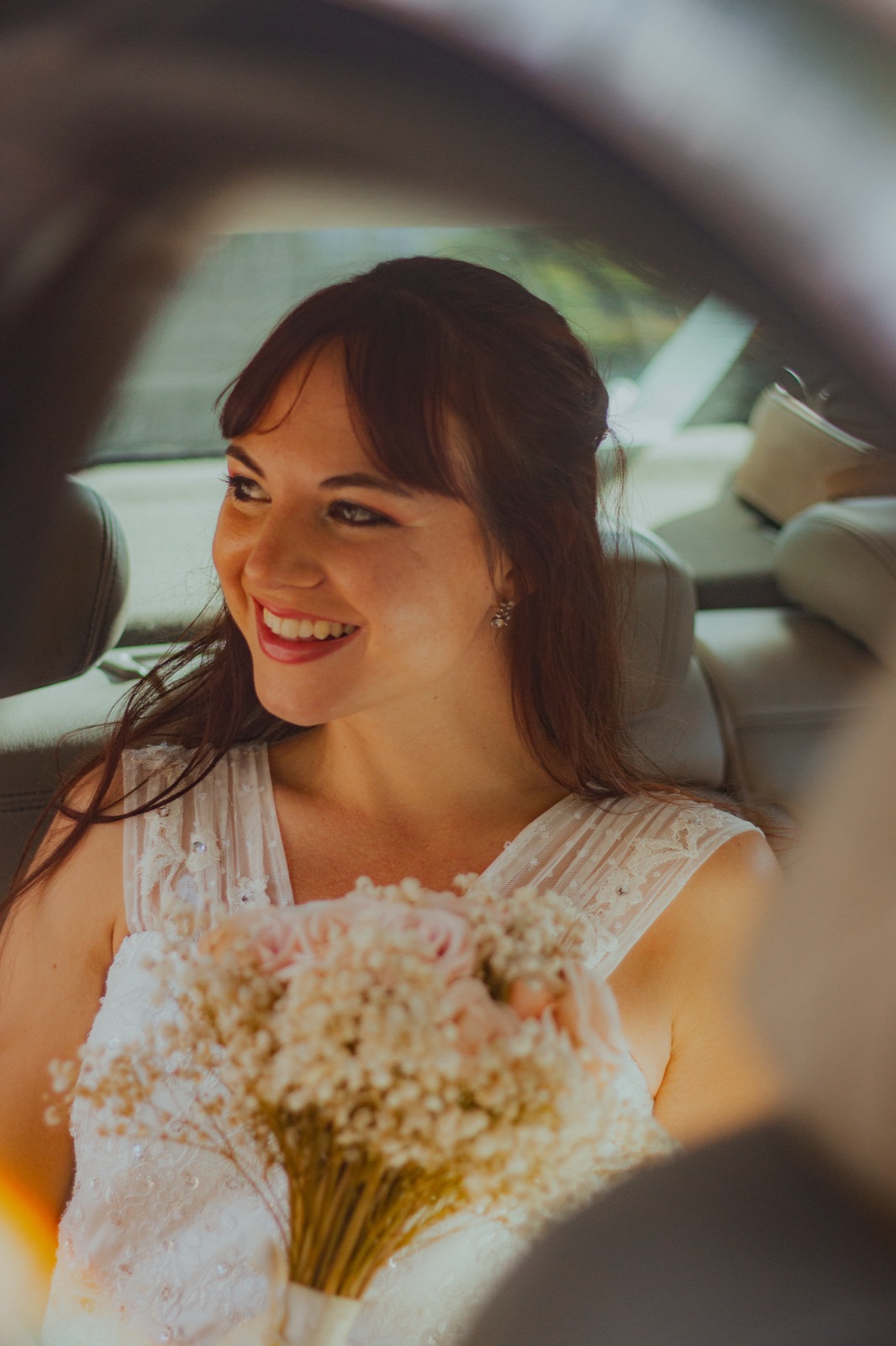 Agus smiles from the car with her bouquet