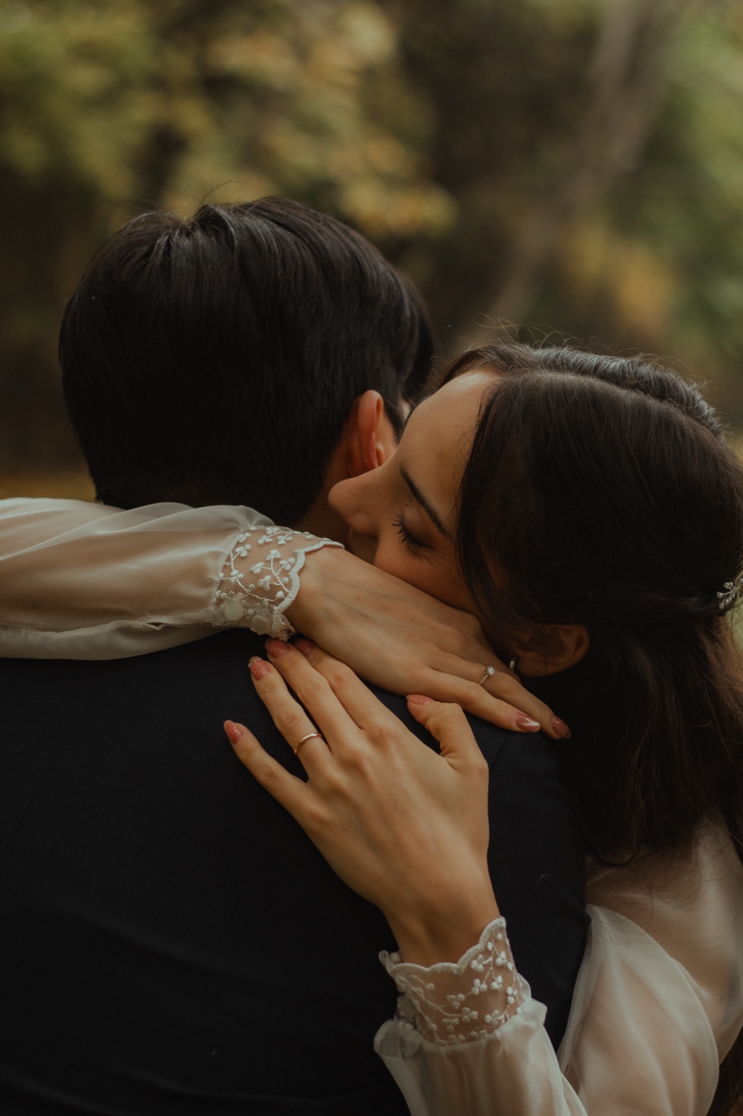Chi Hun and Ludmila embracing among the leaves