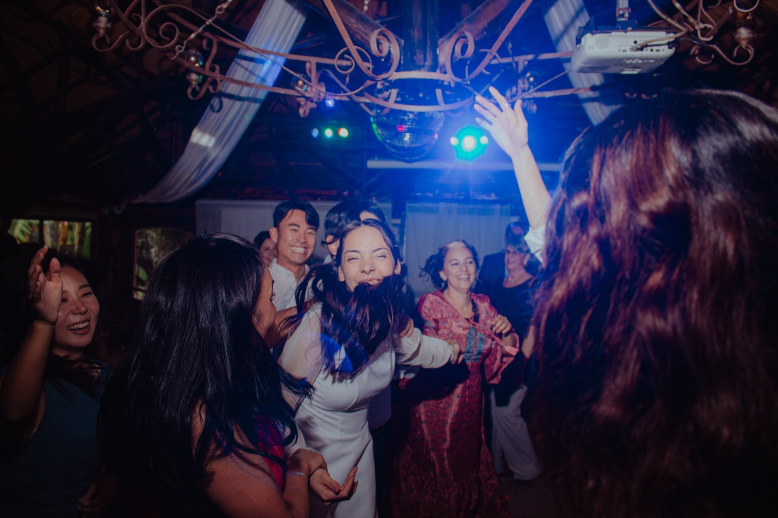 Ludmila dances and laughs with her friends under the dance-floor lights