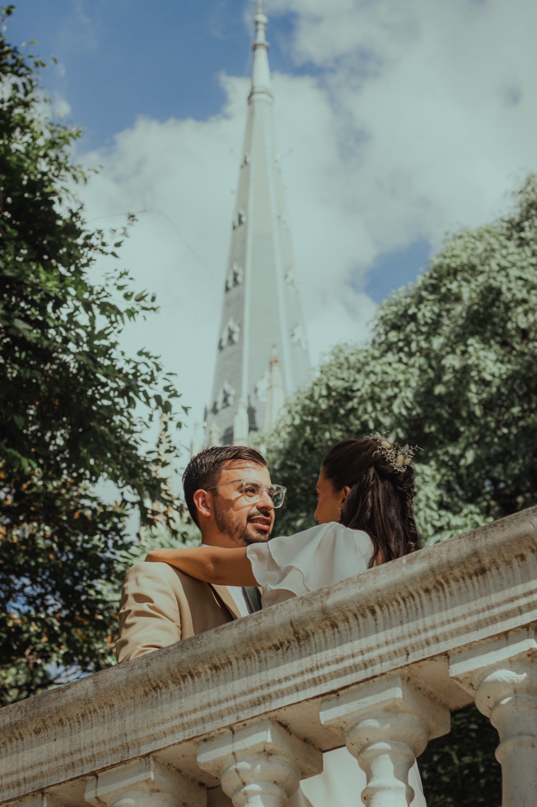 Marcos and Abril look up in front of a tower
