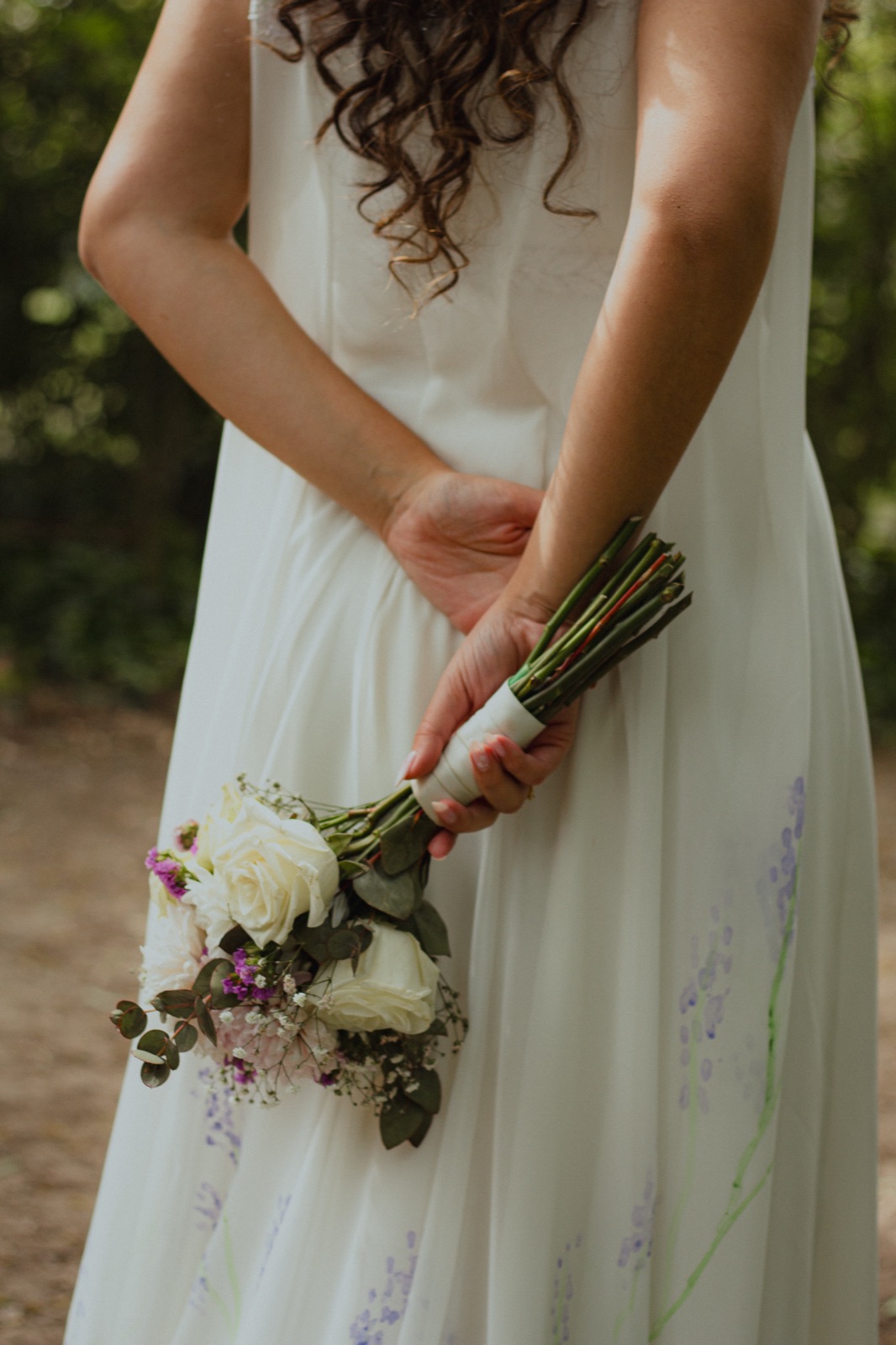 Silvi holds her bouquet behind her back