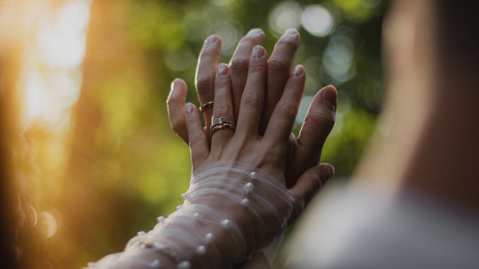 Paco and Mica's hands with their rings, backlit